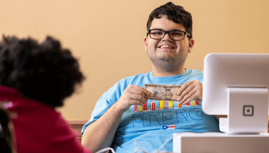 JobSpan - Andrew Smiling holding Dollar for Cash Register