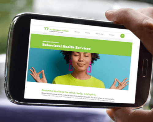 Cell phone with Behavioral Health page of The Children's Institute's website on screen