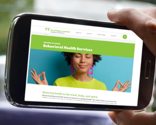 Cell phone with Behavioral Health page of The Children's Institute's website on screen